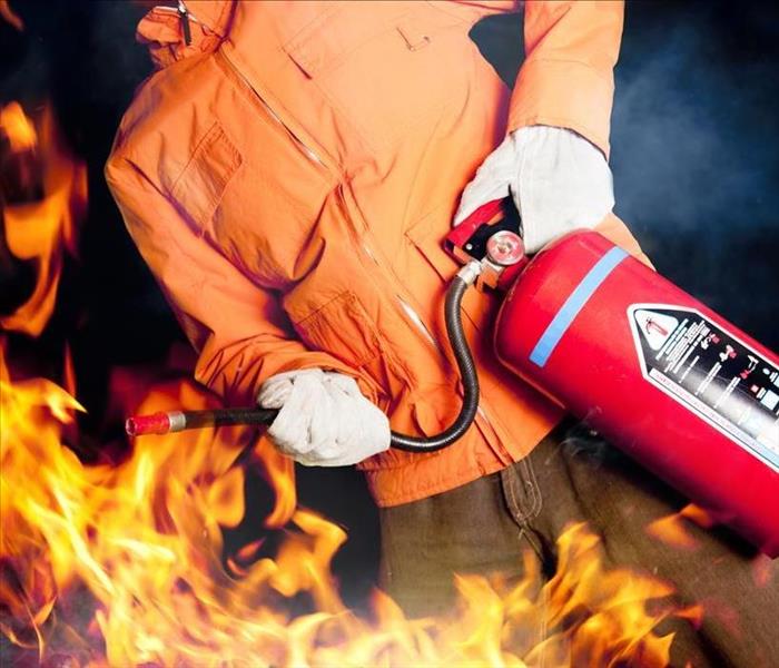 Image of someone using a fire extinguisher to put out a fire