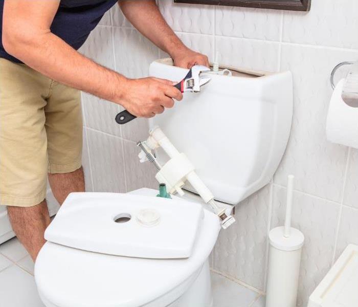 Professional fixing the leak in toilet