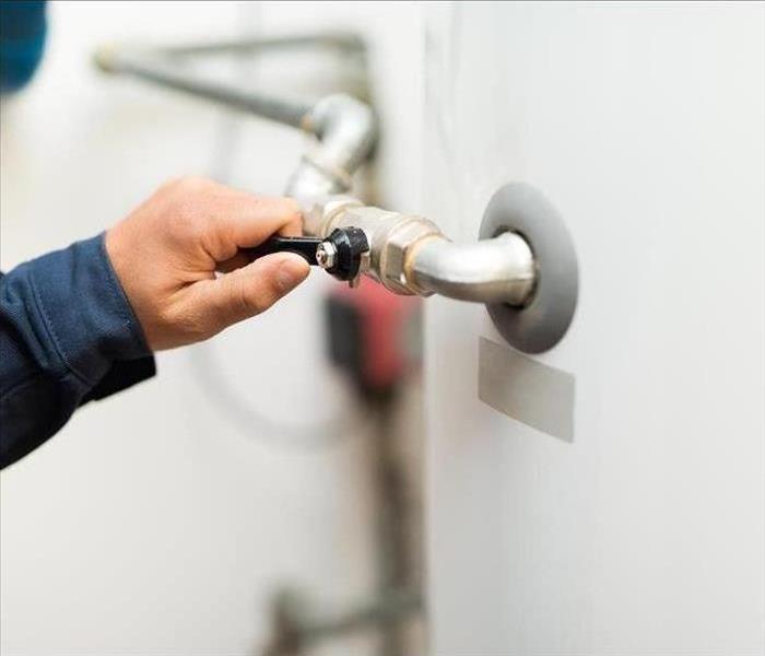 Image of a person flushing a water heater